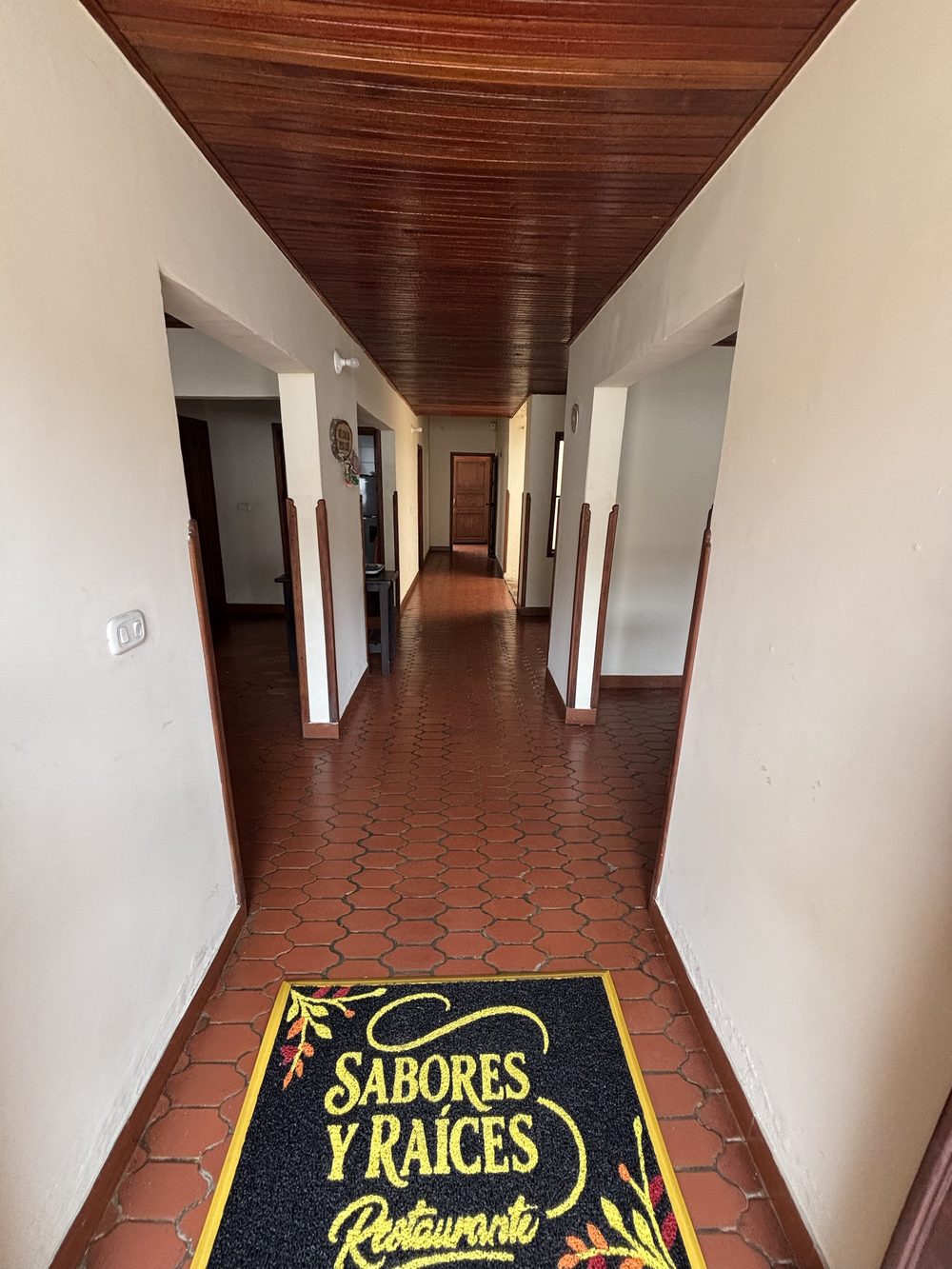 Pasillo de la casa con techo de madera y el tapete del restaurante